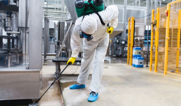 The Pest Management technician in full protective gear treating a commercial facility in Chennai