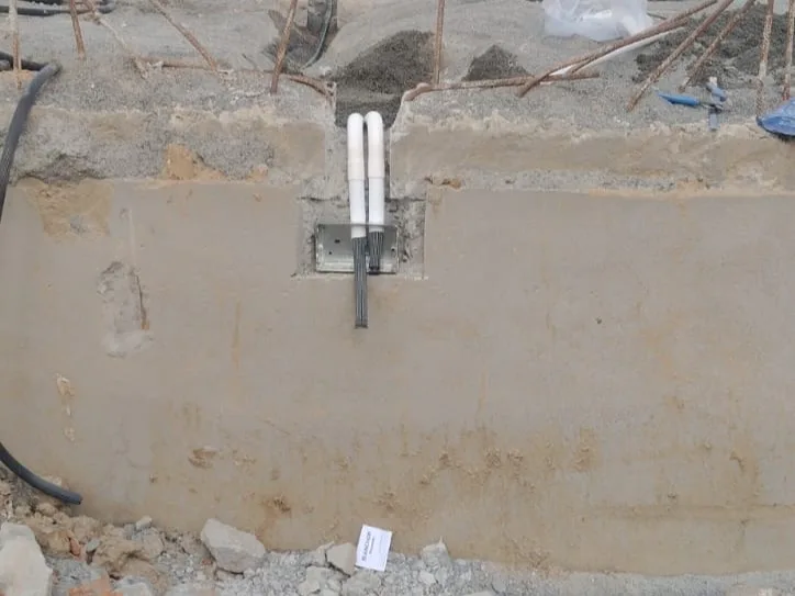 Reticulated anti-termite piping risers installed in a foundation trench, terminating in a concealed inspection box at plinth level