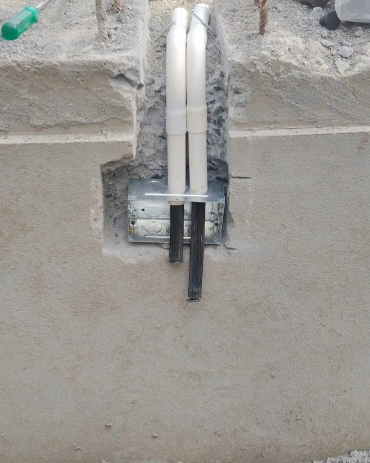 Riser pipes being installed through the plinth into a junction box before plastering